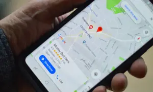 Mano sujetando un móvil con Google Maps. Si te preguntas como saber si me rastrean el móvil, revisa tu ubicación.