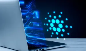 Un portátil muestra un diseño de circuito azul brillante y el logo de Cardano, ilustrando cómo funciona una máquina virtual en un entorno digital.