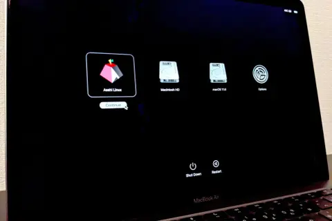 Pantalla de inicio de MacBook Air mostrando opciones de arranque: Asahi Linux, Macintosh HD y macOS 11.6.