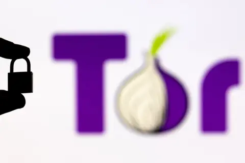 Silueta de mano sosteniendo un candado frente al logo de Tor, el navegador para la deep web.