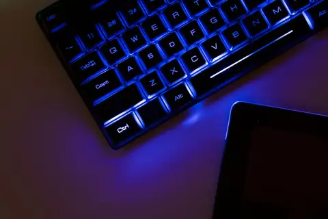 Teclado retroiluminado azul y tablet. Es hora de update drivers para optimizar tu equipo.