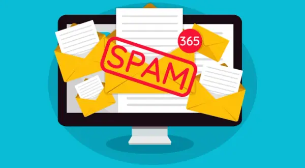 Un ordenador desbordado de sobres amarillos y papeles, con un sello rojo que dice "SPAM". El **spamear significado** es claro: recibir correos no deseados.