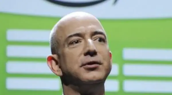 Jeff Bezos, el dueño de Twitch, con el logo de Amazon detrás.