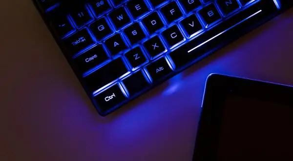 Teclado retroiluminado azul y tablet. Es hora de update drivers para optimizar tu equipo.
