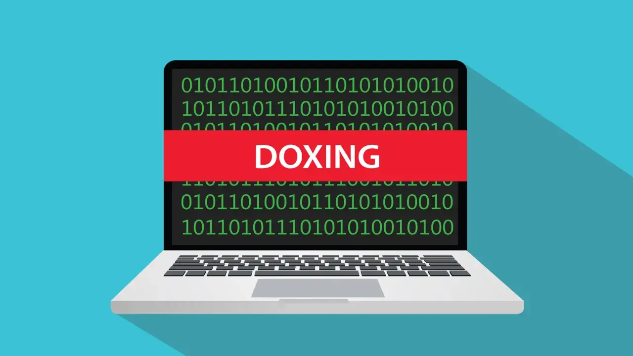 Portátil con código binario y una banda roja que dice "DOXING", ilustrando el doxeo que es.