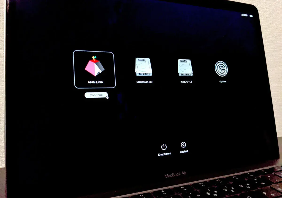 Pantalla de inicio de MacBook Air mostrando opciones de arranque: Asahi Linux, Macintosh HD y macOS 11.6.