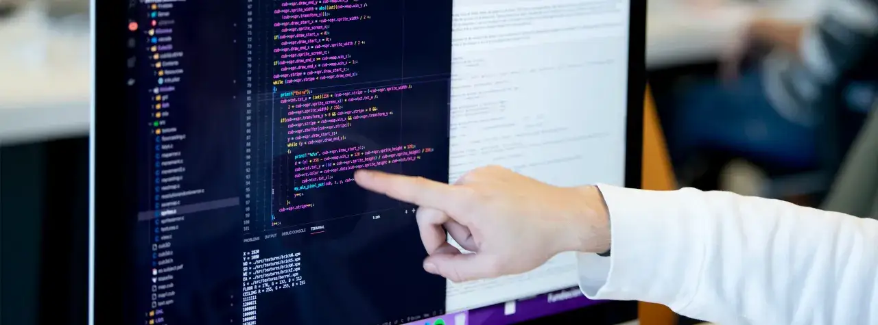 Mano señalando código Python en pantalla, ideal para un curso Python gratis.