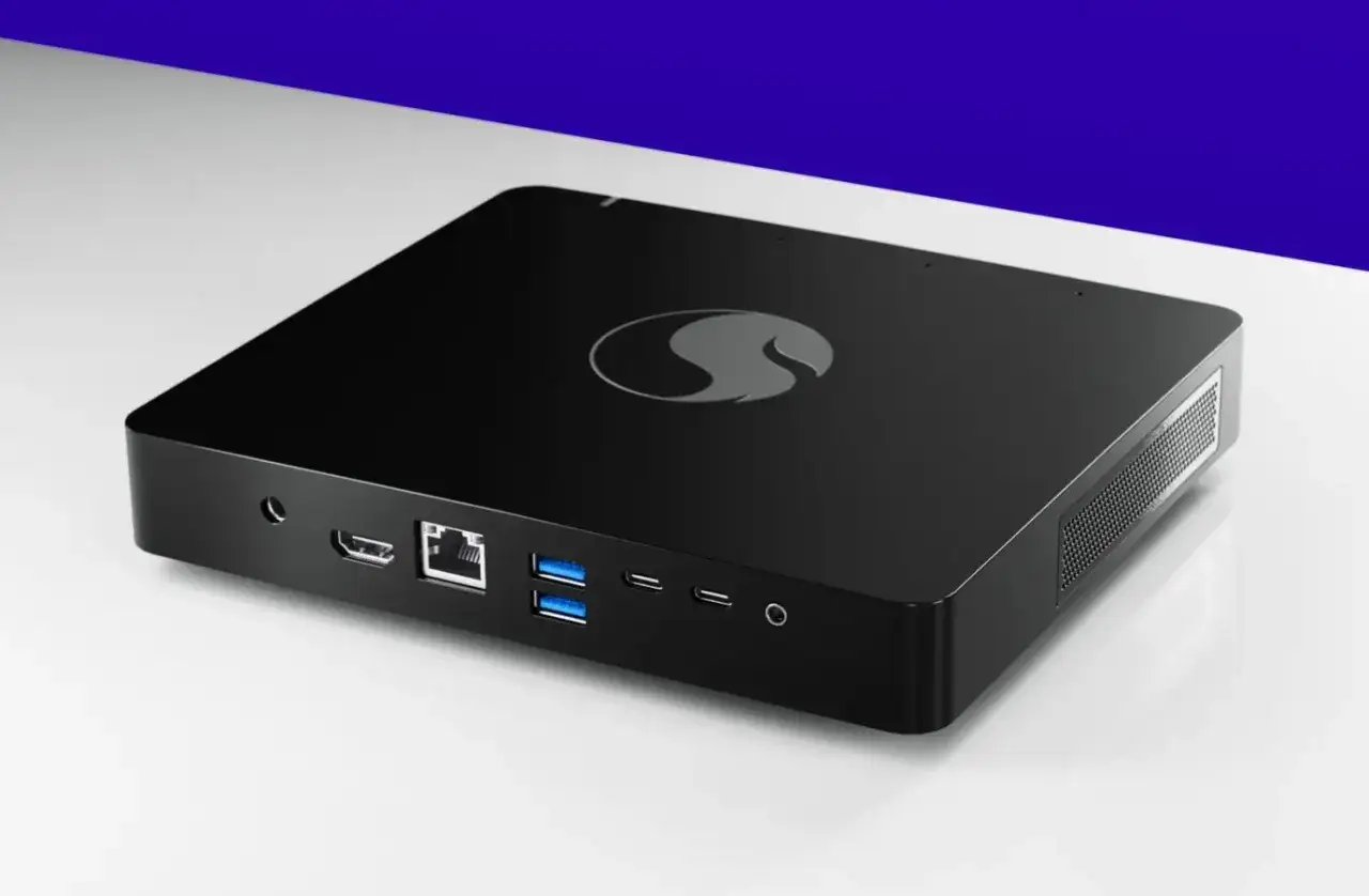 Mini PC negro con logo de Qualcomm, puertos USB, HDMI y Ethernet. Ideal para Windows ARM.