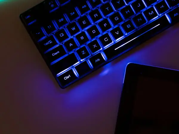 Teclado retroiluminado azul y tablet. Es hora de update drivers para optimizar tu equipo.