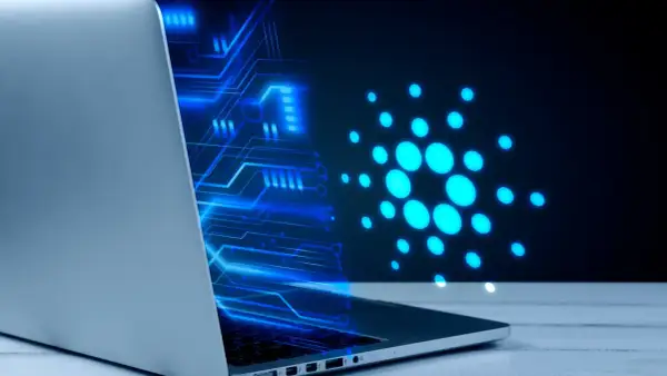 Un portátil muestra un diseño de circuito azul brillante y el logo de Cardano, ilustrando cómo funciona una máquina virtual en un entorno digital.